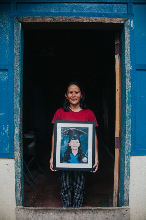 Transform participant holding a frame of her graduation picture